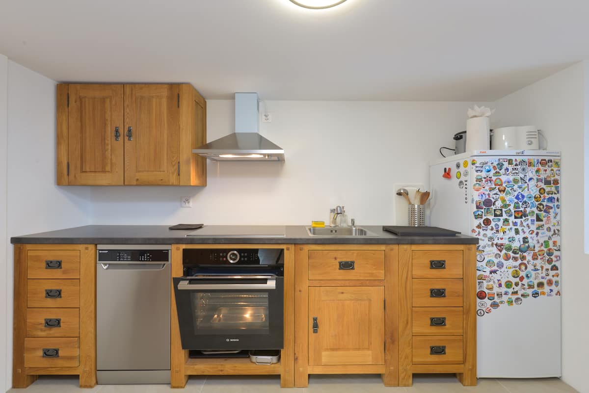 New kitchen with wooden cabinets, stainless appliances and dark worktop