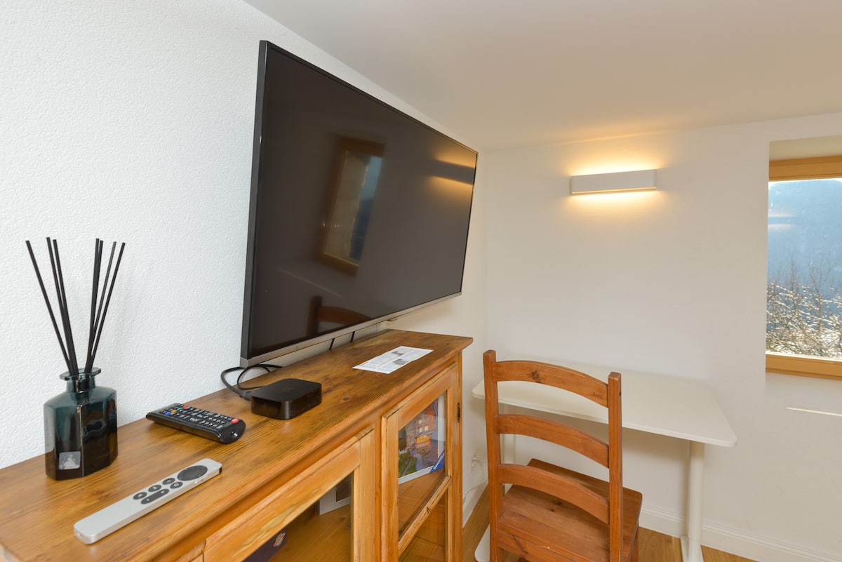Living room corner with wooden console, television and warm lamplight
